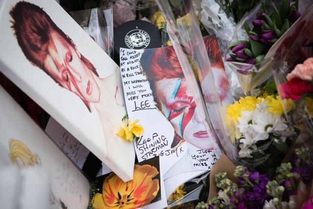 Tributes laid in homage to British singer David Bowie, are seen beneath a mural of the music legend, in Brixton, south London. (AFP) Tributes laid in homage to British singer David Bowie, are seen beneath a mural of the music legend, in Brixton, south London. (AFP)
