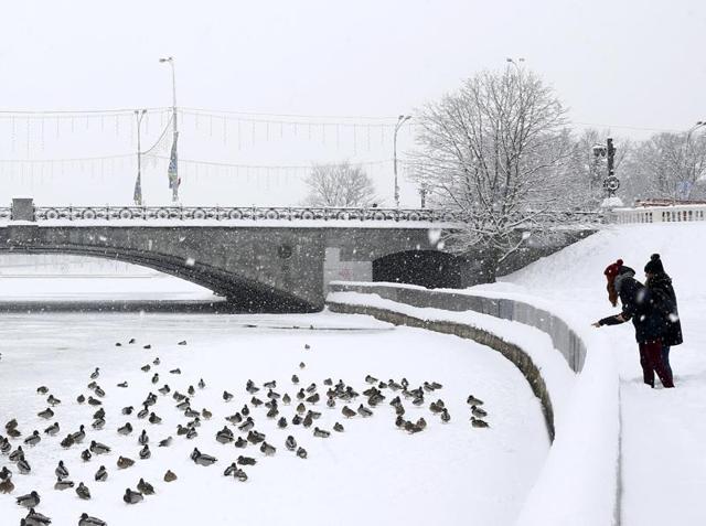 Women stand at a bank of Svisloch river in a park after heavy snowfall in Minsk, Belarus. (REUTERS)