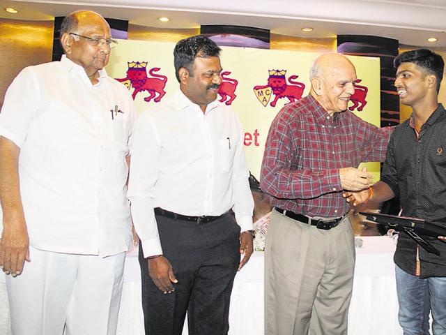 Cricketer Madhavrao Apte, MCA President Sharad Pawar felicitate Pranav Dhanawade, who scored 1,009 runs in an inter-school cricket match, on behalf of Mumbai Cricket Association (MCA). Former cricketer, Pravin Amre was also present at the function.(BHUSHAN KOYANDE)