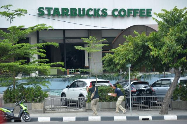 Plainclothes police aim their handguns towards suspects outside a cafe after a series of blasts hit the Indonesia capital Jakarta. (AFP) Plainclothes police aim their handguns towards suspects outside a cafe after a series of blasts hit the Indonesia capital Jakarta. (AFP)