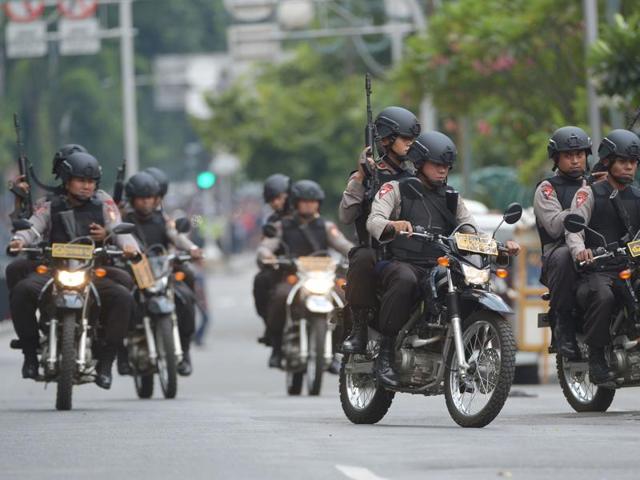 Indonesian policemen arrive to enter a building as armed men exchange shots with police in Jakarta. (AFP Photo) 