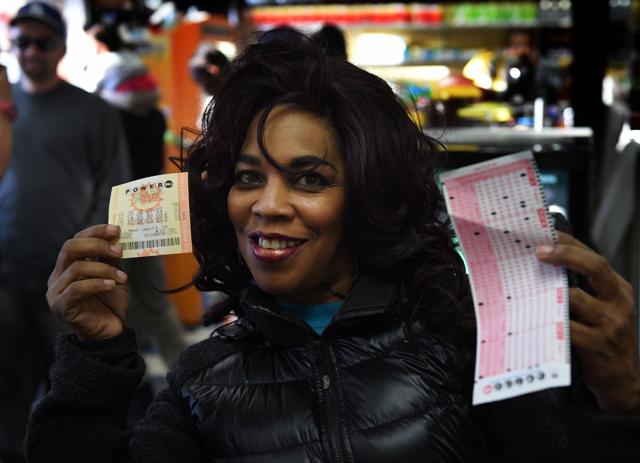 Tania Blazer holds up her California Powerball lottery tickets at the famous Bluebird Liquor store which is considered to be a lucky retailer of tickets. (AFP) Tania Blazer holds up her California Powerball lottery tickets at the famous Bluebird Liquor store which is considered to be a lucky retailer of tickets. (AFP)