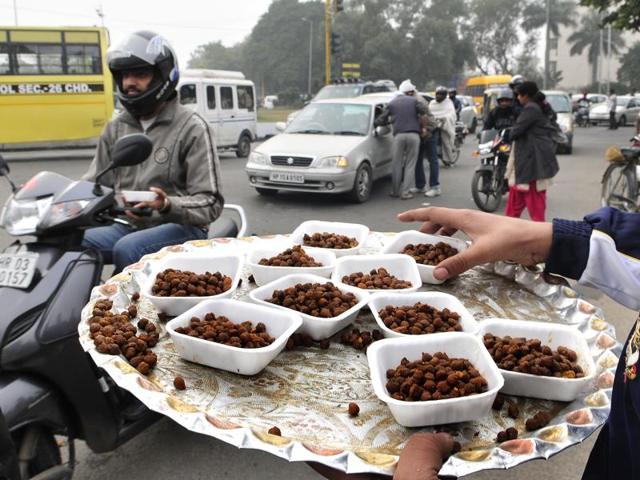 Sewadars distribute prasad (sacred food) to commuters as a part of the Nagar Kirtan. (Keshav Singh/HT Photo)