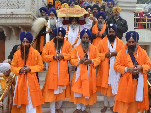 Golden Temple’s head granthi, Giani Jagtar Singh , carrying holy book of Sikh ( Guru Granth Sahib) on his head along with Panj Pyaras during a religious procession in the Parikarma of the temple. (Sameer Sehgal/HT )