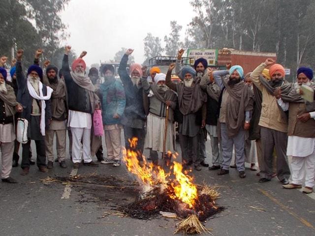 Farmers blocked the Amritsar-Sri Ganganagar national highway during protest and burnt the effigy of Punjab chief minister Parkash Singh Badal at Tarn Taran on Sunday. (HT Photo) Farmers blocked the Amritsar-Sri Ganganagar national highway during protest and burnt the effigy of Punjab chief minister Parkash Singh Badal at Tarn Taran on Sunday. (HT Photo)