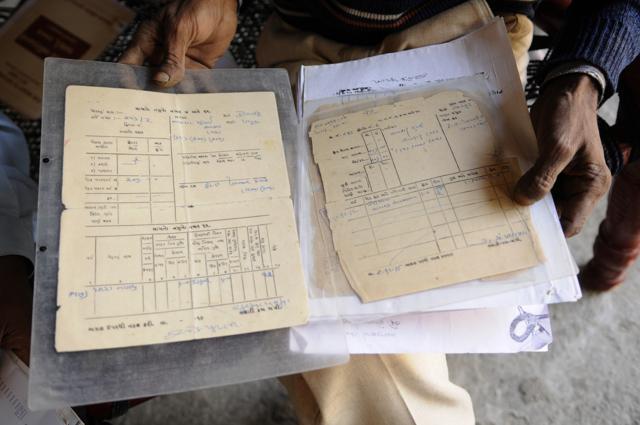 Faljibhai shows documents of his land which are not acknowledged in the computer records of the authorities. (Saumya Khandelwal/ HT Photo) Faljibhai shows documents of his land which are not acknowledged in the computer records of the authorities. (Saumya Khandelwal/ HT Photo)