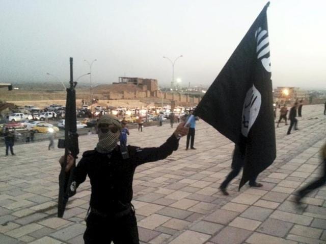 An Islamic State fighter holds an IS flag and a weapon on a street in the city of Mosul in Iraq. According to SOHR, over 400 civilians were abducted by the terrorist organisation in East Syria.(AFP File Photo)