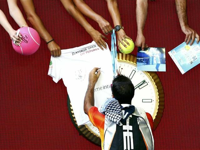 Spain's Fernando Verdasco signs autographs after winning his first round match against Spain's Rafael Nadal at the Australian Open tennis tournament at Melbourne Park. (Thomas Peter / REUTERS) 
