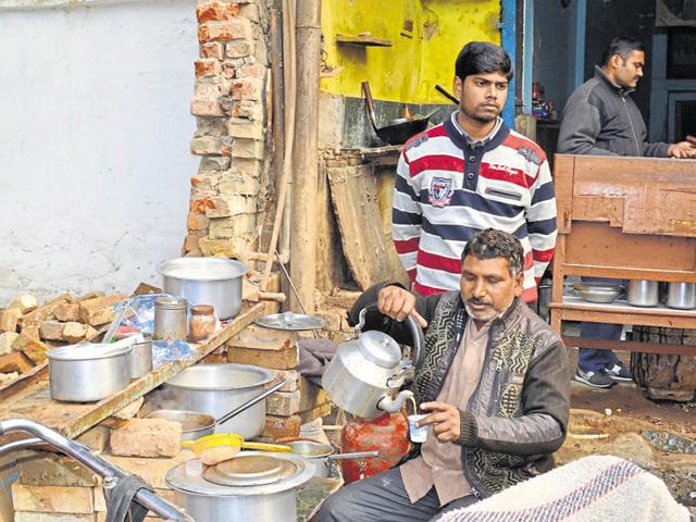 Vishnu Agarwal pours tea at his roadside stall in New Agra while his son Manoj looks on. Vishnu Agarwal pours tea at his roadside stall in New Agra while his son Manoj looks on.