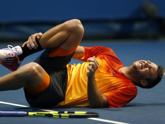 Jack Sock of the United States clutches at his ankle after falling during his first round match against compatriot Taylor Fritz. (Rafiq Maqbool/ AP Photo) 