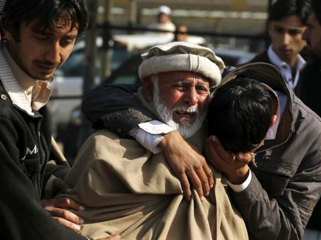 Relatives grieve their loss at the Hayatabad medical complex after a suicide bomber targeted a police checkpoint in Peshawar.(REUTERS)