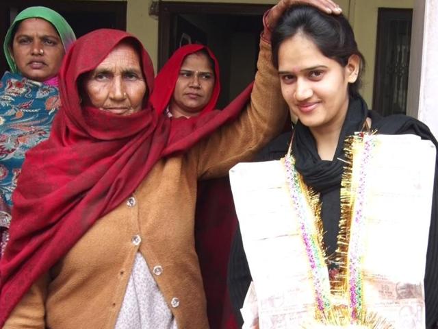 An elderly woman blessing Pooja, the new sarpanch of Shekhpura village of Hisar district , on Monday.(HT Photo)