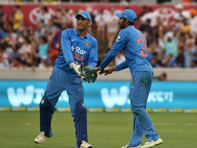 Indian captain MS Dhoni (L) congratulates Gurkeerat Mann (R) on successfully taking a catch. (AFP Photo) 