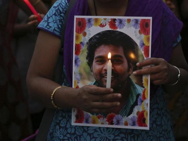Activist of a Dalit organisation participate in a candle light vigil holding photographs of Indian student Rohith Vemula in Hyderabad.(AP)