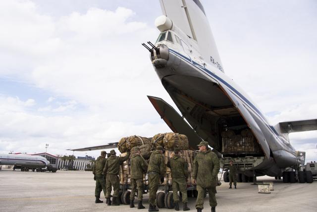 Russian air force personnel prepare to load humanitarian cargo on board a Syrian plane at Hemeimeem air base in Syria, Wednesday, Jan. 20, 2016. (AP Photo)