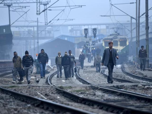 People cross tracks near New Delhi railway station where fog has delayed many trains.  (Arun Sharma/ HT Photo) 