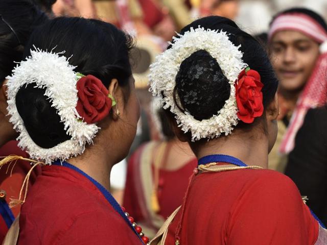 Assamese women with their hair done up prepare for a traditional dance. (Ajay Aggarwal/ HT Photo)