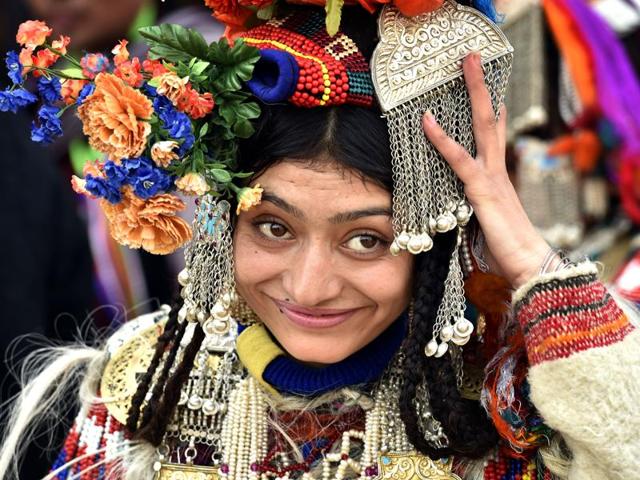 A woman dressed in the traditional attire of Jammu and Kashmir’s Ladakh region adjusts her headgear. (Ajay Aggarwal/ HT Photo)