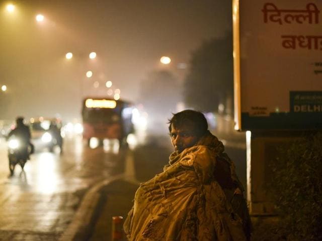 A homeless man tries hard to warm himself as the city witnesses the coldest day of the season. (Arun Sharma / HT Photo) 