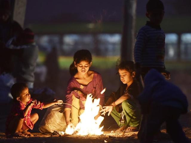 Shelter or not, warmth is necessary: Children sit around a bonfire at Turkman Gate in New Delhi as the mercury in the Capital drops. (Raj K Raj / Hindustan Times) 