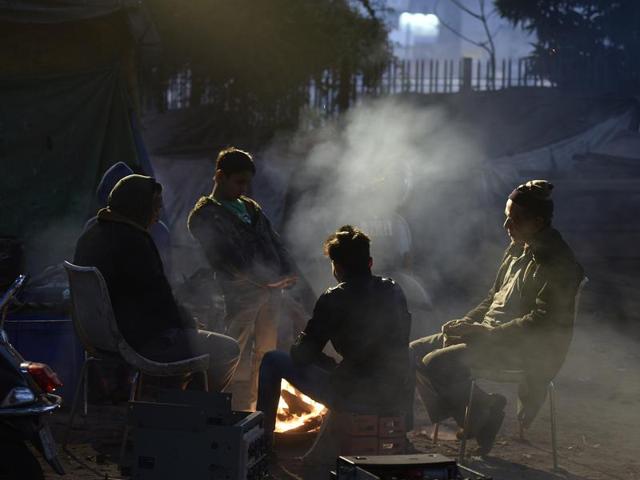 Relief for some, stifle for many: People warm themselves around a bonfire at Turkman Gate in New Delhi. The impact of the smoke on the air quality is unchecked. (Raj K Raj / HT Photo) 