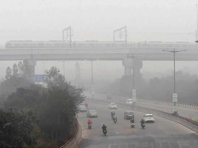 A Metro train runs on its tracks on a cold foggy morning in New Delhi.(PTI)