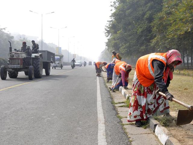Workers cleaning the city roads on Saturday. (Gurminder Singh/HT Photo)