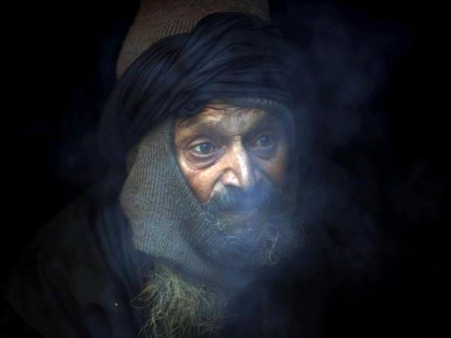 Meanwhile, a Hindu sage sits inside his shelter to keep himself warm. (Navesh Chitrakar/Reuters) Meanwhile, a Hindu sage sits inside his shelter to keep himself warm. (Navesh Chitrakar/Reuters)