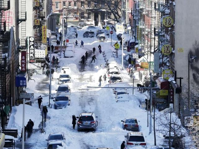 People clear snow from parked cars on Henry Street in the Chinatown neighbourhood in New York.(AP Photo) People clear snow from parked cars on Henry Street in the Chinatown neighbourhood in New York.(AP Photo)