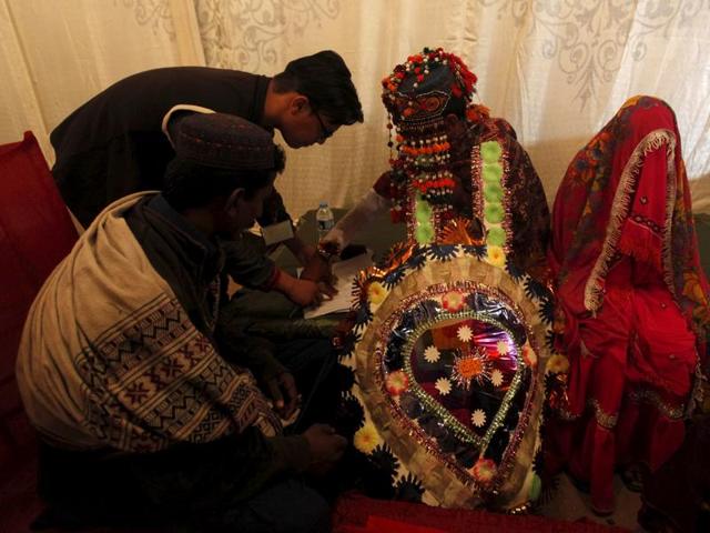 A groom signs marriage documents during a mass marriage ceremony. (REUTERS)