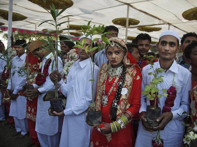 Indian muslim grooms and brides wait to plant trees to start their newly married life on a good note during a mass wedding event in Ahmadabad. (AP)