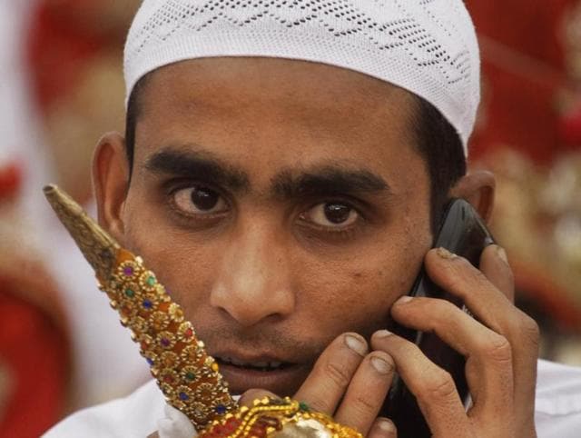 An Indian muslim groom talks on his mobile phone before a mass wedding event in Ahmadabad. (AP)