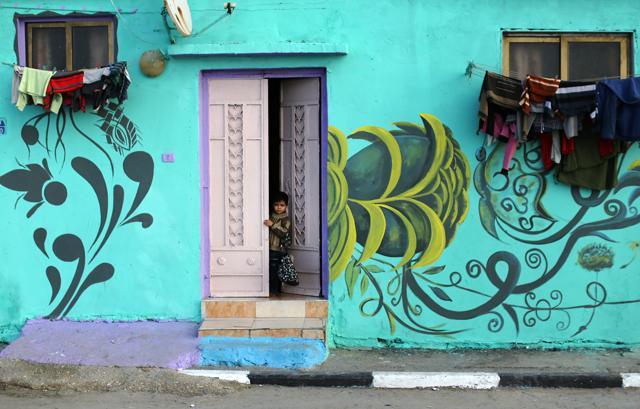 A Palestinian child looks out of a house painted by Palestinian artists in the al-Shati refugee camp in Gaza City. (AFP) A Palestinian child looks out of a house painted by Palestinian artists in the al-Shati refugee camp in Gaza City. (AFP)
