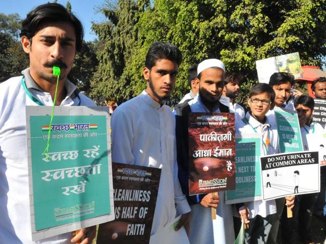 Members of Submission Welfare Society hold placards denouncing urination in public.(Shankar Mourya/HT Photo)