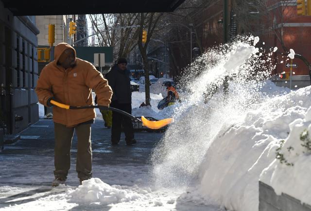A man shovels snow from a sidewalk in New York City on Saturday. (AFP)
