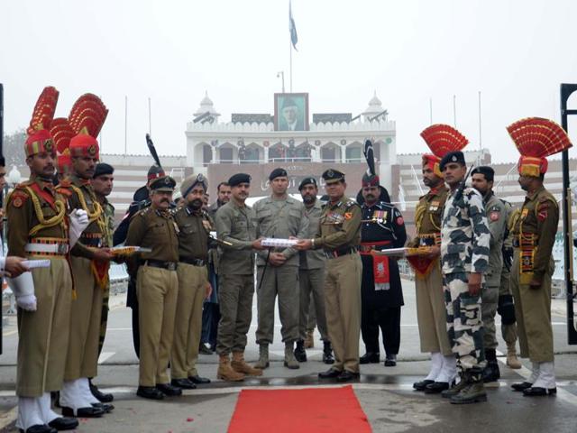 Border Security Force (BSF) DIG Sumer Singh (R) along with other officials offer sweets to Pakistan Rangers wing commander Bilal Ahmed (L) on the occasion of 67th Republic Day celebration at Wagah Border in Attari on Tuesday.  (Sameer Sehgal/HT Photo) 