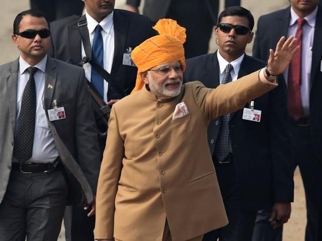 Prime Minister Narendra Modi waves to spectators after the Republic Day Parade in New Delhi. Dressed in a toffee-tan bandhgala suit paired with a saffron turban (reminiscent of his maiden Independence Day speech) and finished with a silken pocket square, Narendra Modi stood out yet again for his sartorial choice at Rajpath.(AFP)