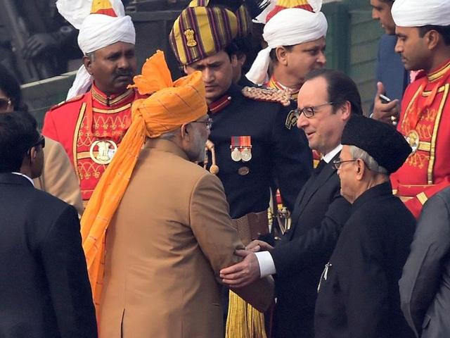 Prime Minister Narendra Modi welcomes French President Francois Hollande (C) as President Pranab Mukherjee (2R) looks on during the Republic Day Parade in New Delhi. (AFP Photo) 