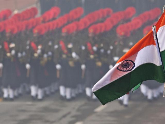 Flags flutter in the foreground as security forces march during the Republic Day parade in New Delhi.  (AP Photo) 