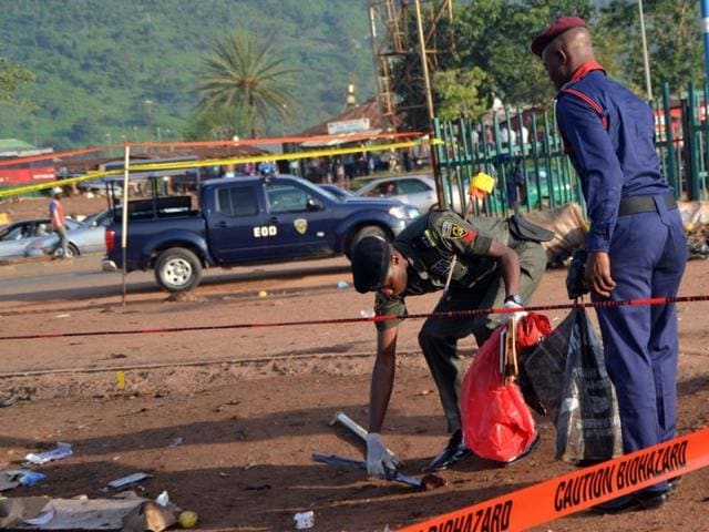 Nigerian bomb experts collect clues from a bomb blast site for analysis in Nyanya, near Abuja.(AFP File Photo)