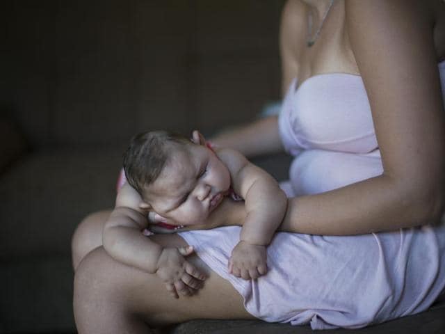 Gleyse Kelly da Silva, 27, holds her daughter Maria Giovanna, who was born with microcephaly, outside their house in Recife, Pernambuco state, Brazil.(AP)