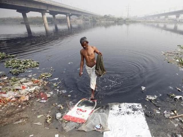A man takes a bath in the polluted waters of river Yamuna on a winter morning in New Delhi.(HT File Photo)