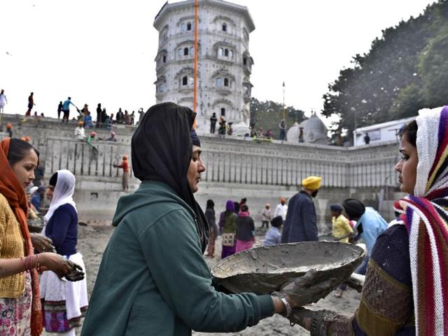 Devotees - men, women and children - carrying and passing on cement during the ‘sewa’ in Amritsar on Thursday. (Gurpreet Singh/HT Photo)