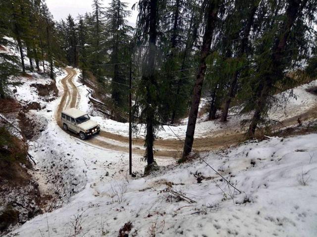 A vechicle moving slowly on a slippery road after snowfall at Kufri near Shimla on Friday. (PTI )