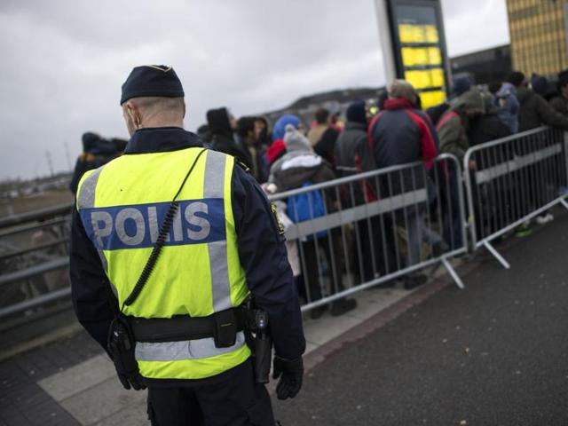 A policeman watches over a queue of newly arrived people, at Hyllie station outside Malmo, Sweden. (AP File Photo) A policeman watches over a queue of newly arrived people, at Hyllie station outside Malmo, Sweden. (AP File Photo)
