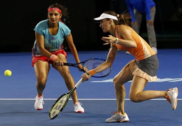Switzerland's Martina Hingis (R) hits the ball as her partner India's Sania Mirza watches during their doubles final match. (REUTERS) Switzerland's Martina Hingis (R) hits the ball as her partner India's Sania Mirza watches during their doubles final match. (REUTERS)