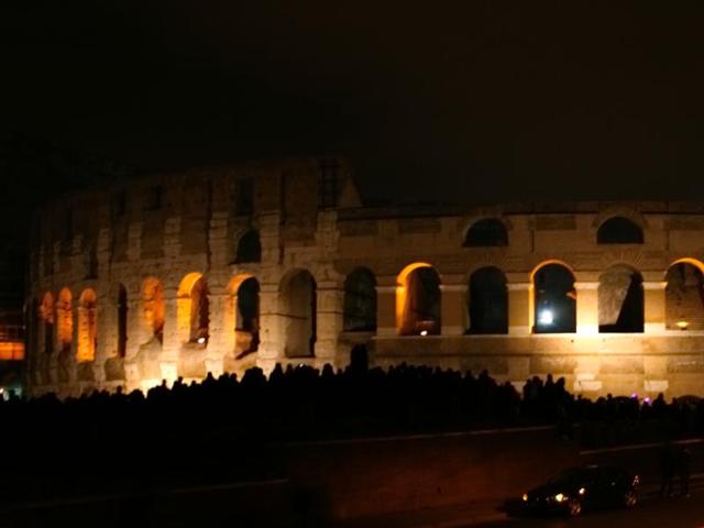 The Colosseum is lit up at night and the silhouette of a crowd gathered at the laws is visible in front of the ancient amphitheatre which used to hold markets, cultural programs and fierce competitions between gladiators and wild animals. (Picture courtesy: Mad Art Photography) The Colosseum is lit up at night and the silhouette of a crowd gathered at the laws is visible in front of the ancient amphitheatre which used to hold markets, cultural programs and fierce competitions between gladiators and wild animals. (Picture courtesy: Mad Art Photography)