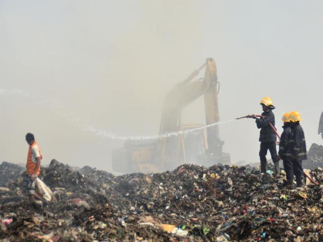Fire personnel trying to extinguish the fire which is been there for past 2 days at Deonar Dumping Ground in Shivaji Nagar in Mumbai. (Prashant Waydande/HT Photo)