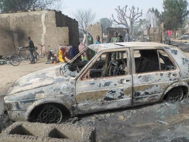 Children gather around a burnt out car following an attack by Boko Haram in Dalori village 5 kilometers from Maiduguri, Nigeria. (AP) Children gather around a burnt out car following an attack by Boko Haram in Dalori village 5 kilometers from Maiduguri, Nigeria. (AP)