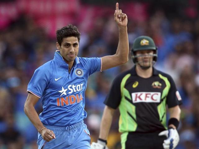 Indian bowler Ashish Nehra points up to the air as he celebrates taking the wicket of Australia's Usman Khawaja. (AP Photo) 